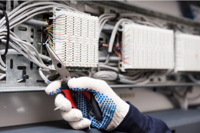 Mann som kutter elektriske ledninger